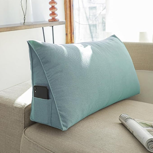 Blue Headboard Pillow Wedge with side pocket placed on beige couch near window