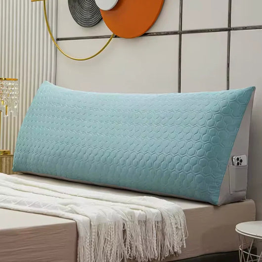 Blue long wedge pillow with textured cover on bed, designed for comfortable back and neck support
