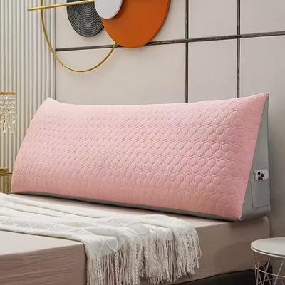 getblissyneck pink Long Wedge Pillow with honeycomb pattern resting against bed headboard